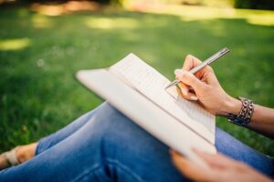 writing in a notebook in the park